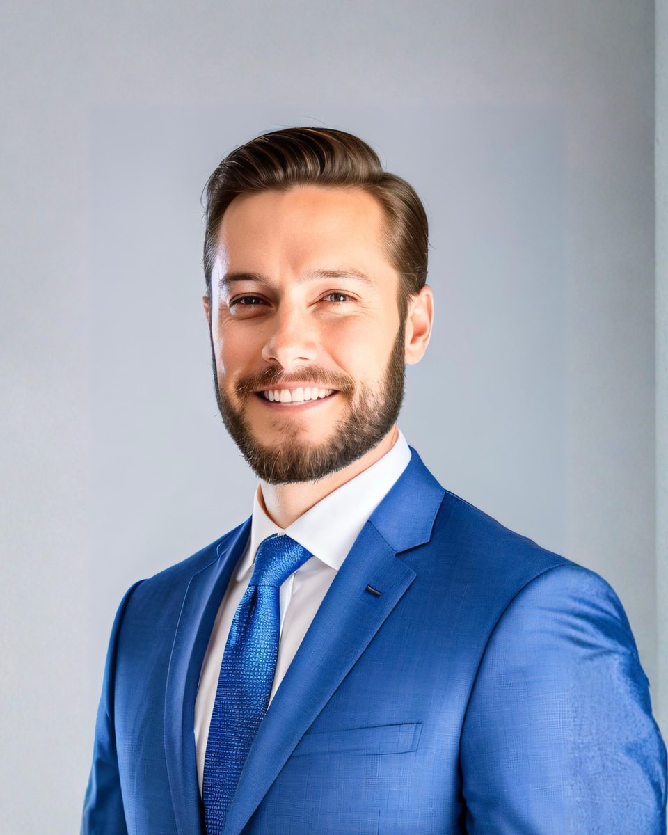 Shane M. Dixon in a blue suit, looking at the camera.
